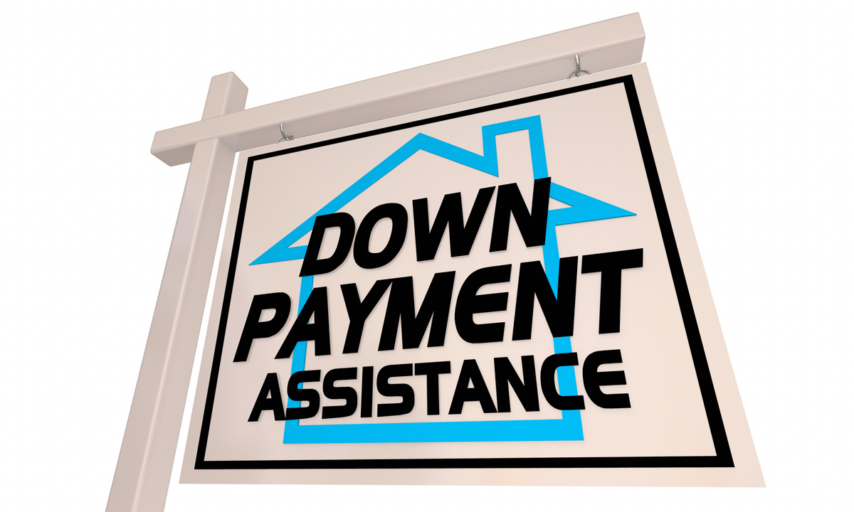 A white sign with a blue house graphic that reads “DOWN PAYMENT ASSISTANCE” in El Paso.