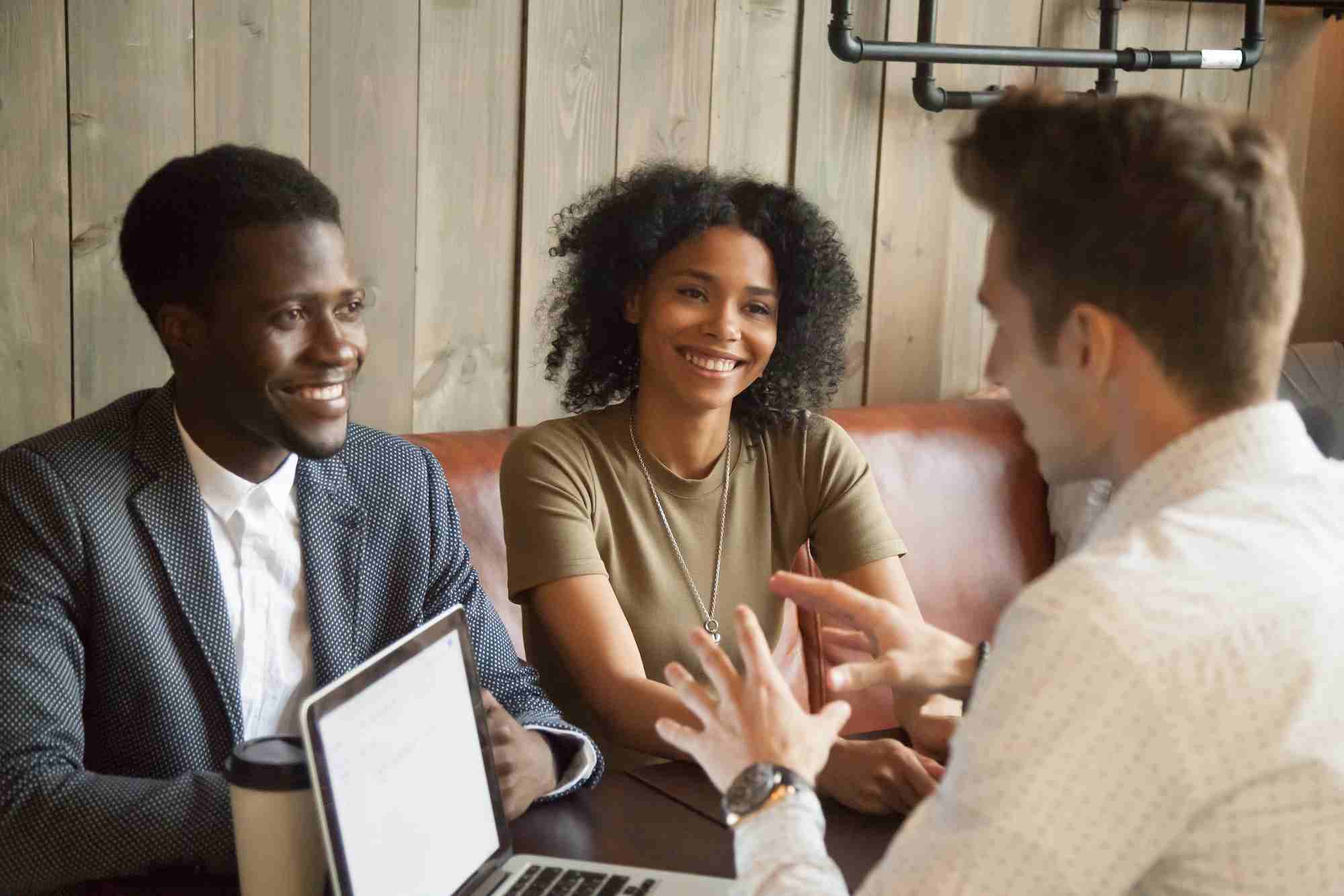 A young couple meeting with their broker to learn more about their down payment in El Paso, TX