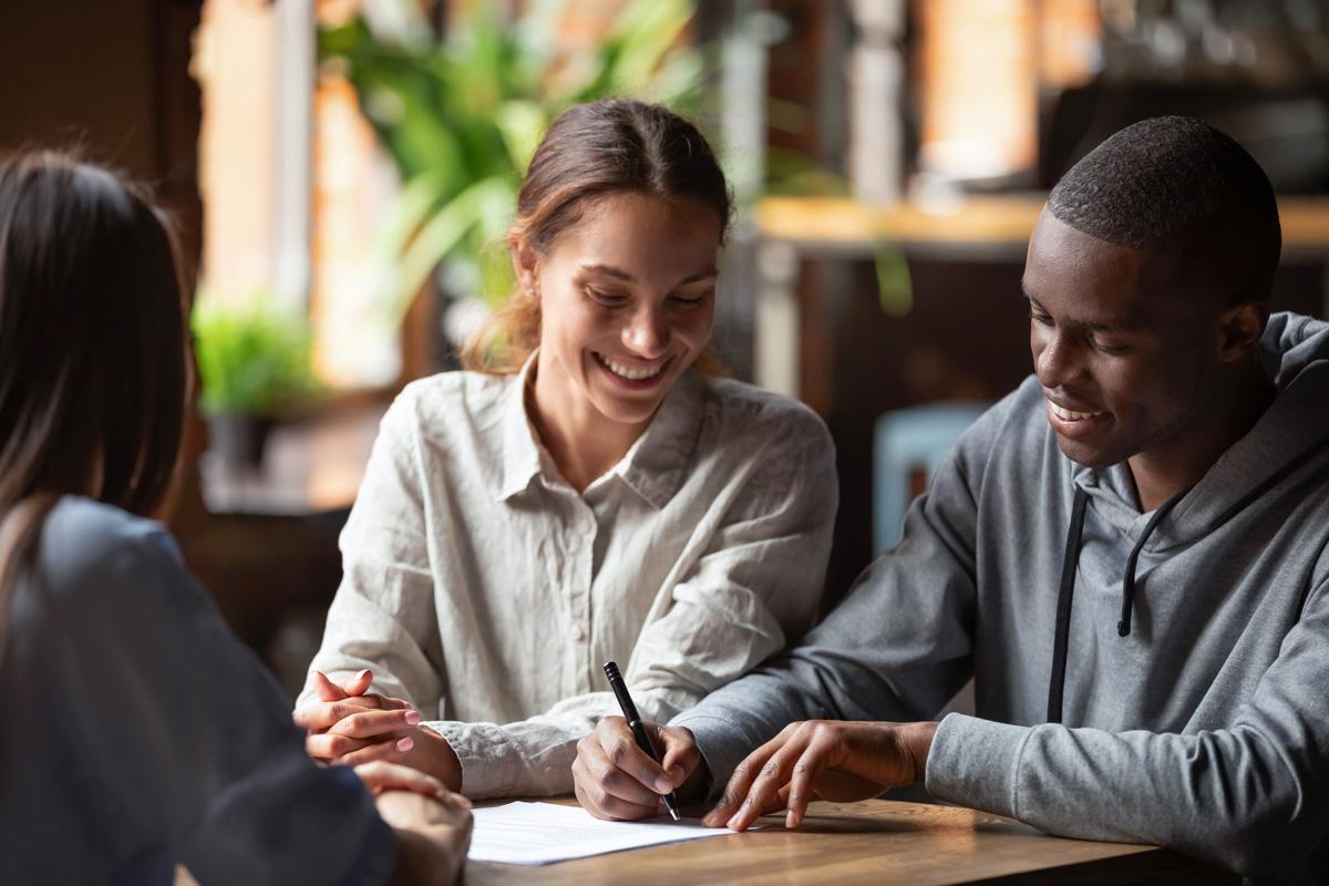 A couple signing papers in front of a mortgage lender in El Paso, TX