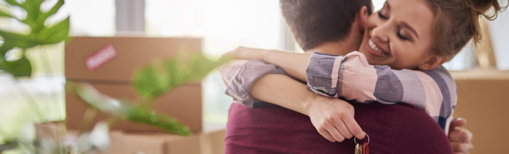 Yong happy couple holding keys to new home. Mortgage Company